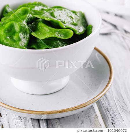 Tasty green dumplings on white bowl Tasty green dumplings on white bowl 101040072