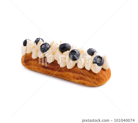 Eclair with buttercream and blueberries isolated Eclair with buttercream and blueberries isolated 101040074