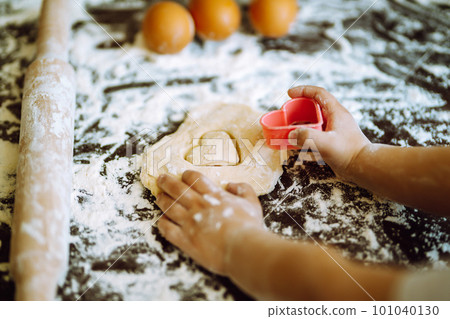 Kids hands cutting out shapes and making cookies. Children's art project, a craft for children. 101040130