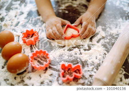 Kids hands cutting out shapes and making cookies. Children's art project, a craft for children. 101040136