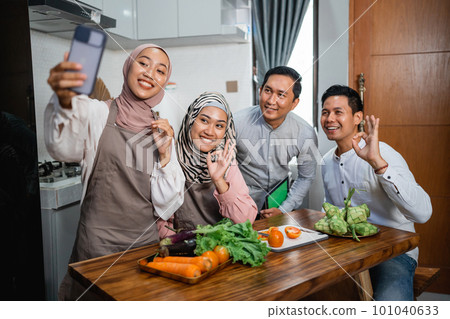friend with hijab looking at the phone to make food 101040633