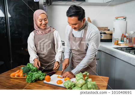 husband and wife enjoy cooking food together in the kitchen husband and wife enjoy cooking food together in the kitchen 101040691