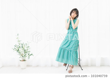 Young woman doing a wishing pose by the window 101040739