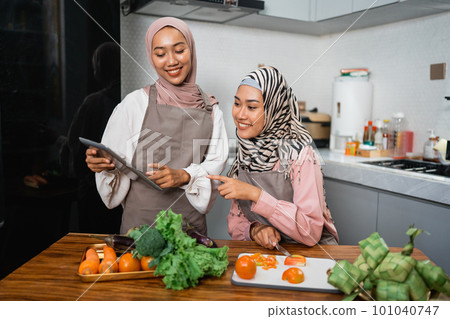 friend with hijab looking at tablet to make new food 101040747