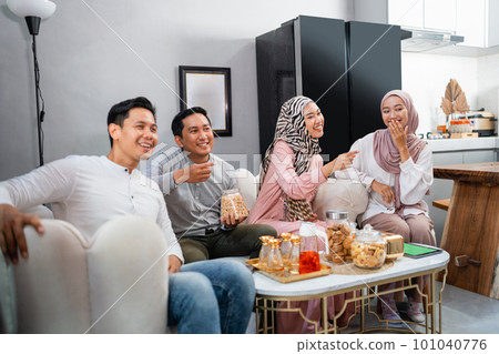 Muslim friends laughing together while watching tv 101040776
