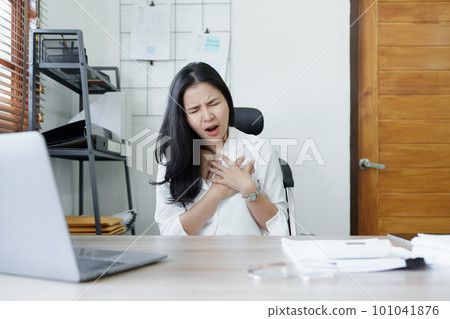 Portrait of young Asian female representative showing acute chest pain from sitting for a long time at work. High quality photo Portrait of young Asian female representative showing acute chest pain from sitting for a long time at work. High quality photo 101041876