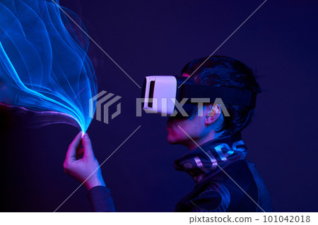 Man is using virtual reality headset to access in metaverse. 101042018