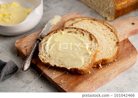 Closeup sourdough slice of homemade white loaf bread with butter.  101042466