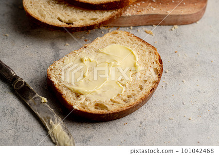 Bread and butter. Closeup sourdough slice of homemade white loaf bread with butter.  101042468