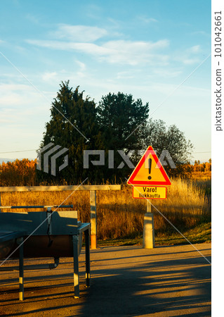 A sign, slippery conditions in finnish language in carpet cleaning place at sunset . Sign warning of slippery conditions. 101042661