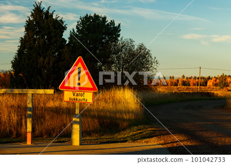 A sign, slippery conditions in finnish language in carpet cleaning place at sunset . Sign warning of slippery conditions. 101042733