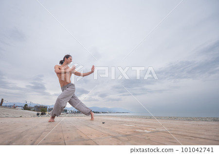 Caucasian man practices martial arts outdoors. balance and meditation. Caucasian man practices martial arts outdoors. balance and meditation. 101042741