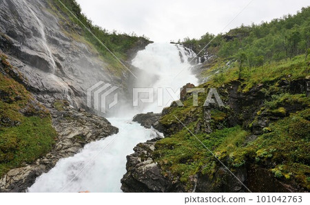 Muddy stream under the platform of Kjos Waterfall Station on the Norwegian Flam Mountain Railway 101042763