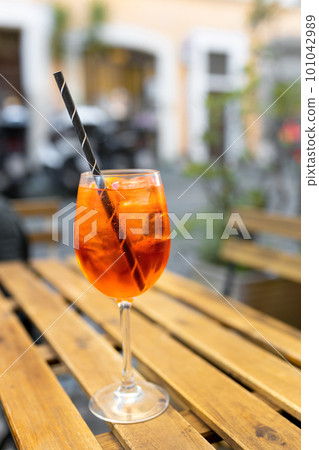 Typical italian alcoholic aperitif served in a bar. Alcoholic beverage based on table with ice cubes and oranges, summer day. Food and drink concept 101042989