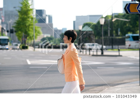 Middle-aged business woman walking in the office district Middle-aged business woman walking in the office district 101043349