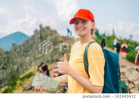 Young woman traveler with a backpack and a map Girl tourist in mountain read the map.Travel and wanderlust concept. Amazing chill moment. Young woman traveler with a backpack and a map Girl tourist in mountain read the map.Travel and wanderlust concept. Amazing chill moment. 101043412