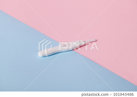 View from above of inkjet pregnancy test with two bars, showing positive reaction between female urine and chg hormone, isolated bicolor pink and blue background. Women's health and Planning maternity 101043486