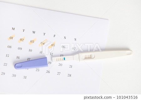 Top view inkjet pregnancy test with two bars on white calendar with the menstruation last days marked. The concept of calculating ovulation and fertile dates for sure implantation, Planning maternity Top view inkjet pregnancy test with two bars on white calendar with the menstruation last days marked. The concept of calculating ovulation and fertile dates for sure implantation, Planning maternity 101043516
