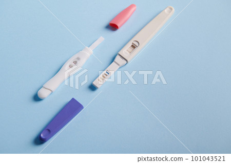 Top view inkjet pregnancy tests with taking place biochemical reaction between female urine and chg hormone, appearing in two bars, showing positive result over blue background. Finally pregnant Top view inkjet pregnancy tests with taking place biochemical reaction between female urine and chg hormone, appearing in two bars, showing positive result over blue background. Finally pregnant 101043521