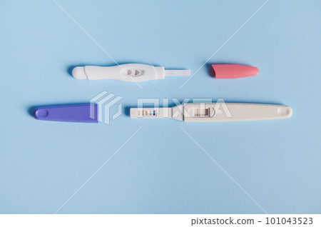 Top view inkjet pregnancy tests with taking place biochemical reaction between female urine and chorionic human gonadotropin hormone, appearing in two bars, over blue background. Finally pregnant 101043523