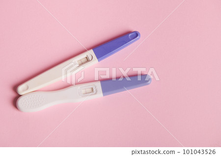 Top view inkjet pregnancy tests with taking place biochemical reaction between female urine and chorionic human gonadotropin hormone, appearing in two bars, over pink background. Finally pregnant Top view inkjet pregnancy tests with taking place biochemical reaction between female urine and chorionic human gonadotropin hormone, appearing in two bars, over pink background. Finally pregnant 101043526