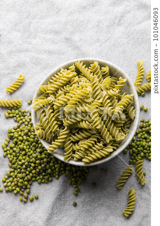 Mung bean fusilli pasta on a gray textile background. 101046093