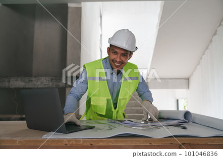 Architect or Engineer working with blueprints for architectural plan, engineer sketching a construction project, green energy concept 101046836