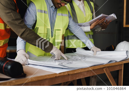 Architect and Engineer working with blueprints for architectural plan, engineer sketching a construction project, green energy concept Architect and Engineer working with blueprints for architectural plan, engineer sketching a construction project, green energy concept 101046864