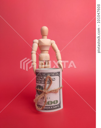 Wooden mannequin holding banknotes on a red background. Wooden mannequin holding banknotes on a red background. 101047608
