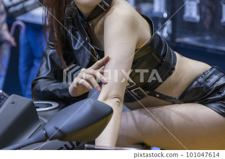 靠在摩托車上擺姿勢的競選女郎 靠在摩托車上擺姿勢的競選女郎 101047614