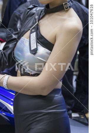 在車展上站在車輛旁邊的女人的上半身 101047616