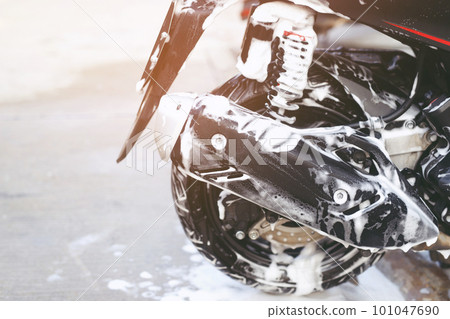 The worker is washing the motorcycle at Car Care. 101047690