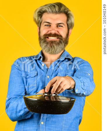 Cooking food concept. Hold frying pan. best quality. bearded cook portrait with kitchen tools. bearded man hold cooking pan. cook preparing food in kitchen. husband on kitchen. selective focus Cooking food concept. Hold frying pan. best quality. bearded cook portrait with kitchen tools. bearded man hold cooking pan. cook preparing food in kitchen. husband on kitchen. selective focus 101048149