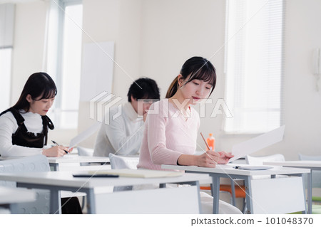 Candidates in plain clothes taking an exam Candidates in plain clothes taking an exam 101048370