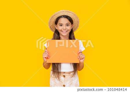 smiling teen girl with copy space on orange paper on yellow background 101048414