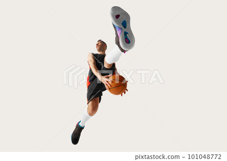 Image of young streetball player wearing sport clothes jumping over with ball over white background Image of young streetball player wearing sport clothes jumping over with ball over white background 101048772