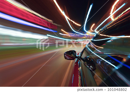 Long exposure of a speedy night drive in a big city 101048802