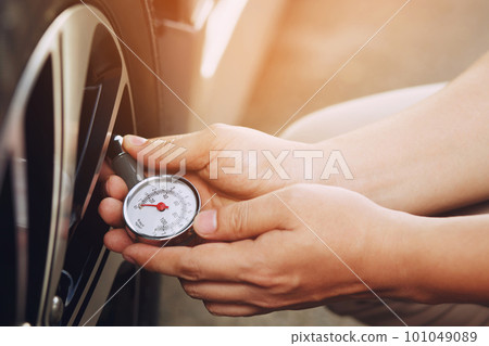 close up hand man car parking a check and inflate the tire fill up the air for safe driving on the go. Transportation travel vehicle concept. 101049089