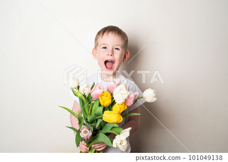 Smiling child with open mouth holding bouquet of flowers 101049138