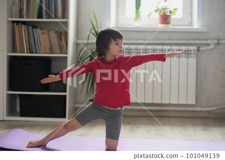 Child doing sports in the room at home 101049139