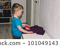 Boy ironing a t-shirt with a toy iron 101049143
