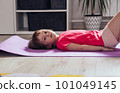 Girl lying on mat after workout at home 101049145