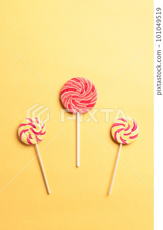 colorful swirl lollipops on a yellow background. colorful swirl lollipops on a yellow background. 101049519