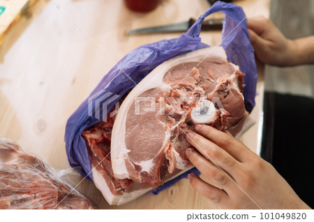 Pork part of the chop in purple bag on wooden table 101049820