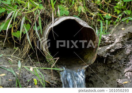 Water flowing from the open outlet of a metal agriculture drainage tile Water flowing from the open outlet of a metal agriculture drainage tile 101050293