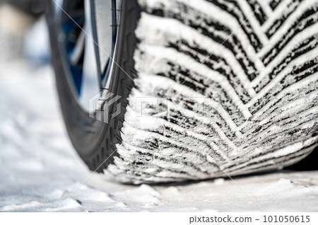 Closeup selective focus on snow packed in an all-weather tire tread. Closeup selective focus on snow packed in an all-weather tire tread. 101050615