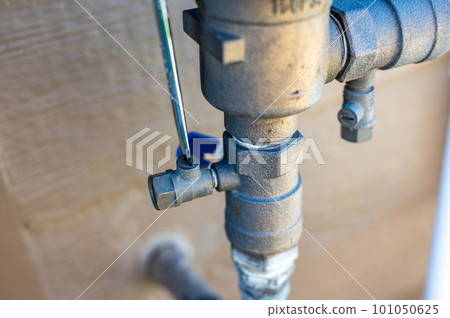 Using a flathead screwdriver to close the test cock next to the vacuum breaker to startup a sprinkler irrigation system in the spring Using a flathead screwdriver to close the test cock next to the vacuum breaker to startup a sprinkler irrigation system in the spring 101050625