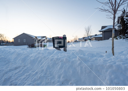 Residential mailbox blocked by a snow pile left by a plow after clearing a street. 101050803