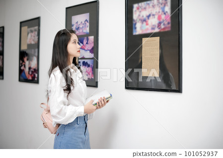 Female student looking at an information board in the museum Female student looking at an information board in the museum 101052937