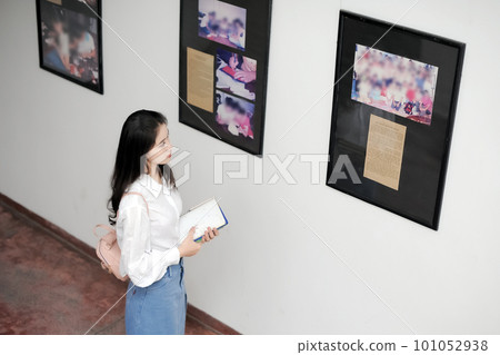 Female student looking at information boards in a museum Female student looking at information boards in a museum 101052938
